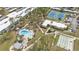 Aerial view of community amenities showcasing a pool, tennis courts, shuffleboard, and clubhouse at 21287 Gertrude Ave # 106, Port Charlotte, FL 33952