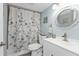 This bathroom is designed with a floral-patterned shower curtain and a modern vanity at 21287 Gertrude Ave # 106, Port Charlotte, FL 33952