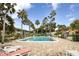 A beautiful community pool surrounded by lush tropical landscaping and lounge chairs at 21287 Gertrude Ave # 106, Port Charlotte, FL 33952