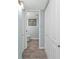 View of the hallway leading to a bathroom with white doors, tile floors and light blue walls at 21287 Gertrude Ave # 106, Port Charlotte, FL 33952
