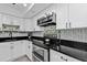 This kitchen features modern appliances, white cabinets, and sleek black countertops at 21287 Gertrude Ave # 106, Port Charlotte, FL 33952
