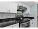 Updated kitchen features stainless steel appliances, white cabinets and modern backsplash at 21287 Gertrude Ave # 106, Port Charlotte, FL 33952