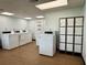 Well-lit laundry room with multiple washing machines and secure storage lockers for tenant convenience at 21287 Gertrude Ave # 106, Port Charlotte, FL 33952