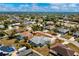 An aerial view shows a home with a light roof, surrounded by lush green landscaping in a neighborhood setting at 21332 Walling Ct, Port Charlotte, FL 33954