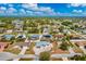 Overhead aerial perspective of a single-story house nestled in a tranquil residential area surrounded by trees at 21332 Walling Ct, Port Charlotte, FL 33954