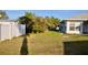 Spacious backyard featuring lush grass, a white fence, and an exterior view of the home at 21332 Walling Ct, Port Charlotte, FL 33954