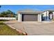 Charming home featuring a gray garage door, driveway, and a well-maintained lawn at 21332 Walling Ct, Port Charlotte, FL 33954
