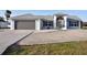 Exterior view of a light-colored home with a well-kept lawn, a two-car garage, and a front entrance at 21332 Walling Ct, Port Charlotte, FL 33954