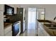 View of kitchen with stainless steel appliances leading to bright sunroom at 21332 Walling Ct, Port Charlotte, FL 33954