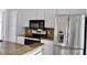 Modern kitchen features stainless steel refrigerator, black oven, and granite countertops at 21332 Walling Ct, Port Charlotte, FL 33954
