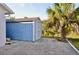 Blue shed with adjacent green grass, gravel, palm trees, and blue skies at 21332 Walling Ct, Port Charlotte, FL 33954