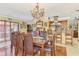 This spacious dining area features wood floors, a glass table with eight chairs and an elegant chandelier at 24485 Tangerine Ave, Punta Gorda, FL 33980