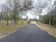 Long paved driveway lined with mature trees leads to a property entrance at 24485 Tangerine Ave, Punta Gorda, FL 33980