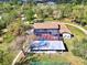 Aerial view of a house with a screened in pool and an outdoor structure next to a tennis court at 24485 Tangerine Ave, Punta Gorda, FL 33980