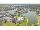 Impressive aerial view of a community with a lake, pool, lush landscaping, and many beautiful homes at 24528 Sunrise Dr, Punta Gorda, FL 33980