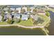 A scenic aerial shot showcases stunning waterfront homes surrounded by rock lined lake, mature landscaping, and lush green lawns at 24528 Sunrise Dr, Punta Gorda, FL 33980