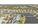 An elevated view of a lakeside neighborhood with manicured lawns, mature trees, and meticulously maintained homes on a clear day at 24528 Sunrise Dr, Punta Gorda, FL 33980
