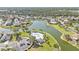 Remarkable aerial view of a community with a lake, pool, lush landscaping, and many beautiful homes at 24528 Sunrise Dr, Punta Gorda, FL 33980