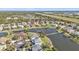 An aerial view shows homes with manicured lawns in a tranquil lakeside community with mature trees, under a sunny blue sky at 24528 Sunrise Dr, Punta Gorda, FL 33980