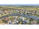 Beautiful homes line a tranquil lake in this aerial view of a well-maintained community with manicured lawns and mature trees at 24528 Sunrise Dr, Punta Gorda, FL 33980