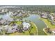 Lovely aerial view of a community with a lake, pool, lush landscaping, and many beautiful homes at 24528 Sunrise Dr, Punta Gorda, FL 33980