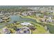 Stunning aerial view of a community with a lake, pool, lush landscaping, and many beautiful homes at 24528 Sunrise Dr, Punta Gorda, FL 33980