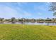 Beautiful backyard lake view surrounded by lush green grass and a blue sky at 24528 Sunrise Dr, Punta Gorda, FL 33980