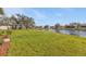 Spacious backyard featuring lush green grass and a serene pond view perfect for outdoor enjoyment at 24528 Sunrise Dr, Punta Gorda, FL 33980