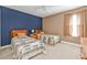Inviting bedroom with two beds, a blue accent wall, and ample natural light at 24528 Sunrise Dr, Punta Gorda, FL 33980