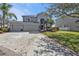 Spacious home featuring a three-car garage, lush landscaping, and a well-maintained lawn at 24528 Sunrise Dr, Punta Gorda, FL 33980