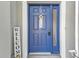 Charming blue front door with a welcoming wreath and a side window for added natural light at 24528 Sunrise Dr, Punta Gorda, FL 33980