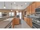 Open concept kitchen with a breakfast bar overlooking a sink with stainless steel appliances and wooden cabinetry at 24528 Sunrise Dr, Punta Gorda, FL 33980
