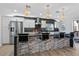 Modern kitchen featuring a large island, pendant lights, and stainless steel fridge at 2476 N Beach Rd, Englewood, FL 34223