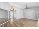 Open living room featuring wood floors, a ceiling fan, elegant light fixture, and mirrored wall accent at 3115 Guadalupe Dr, Punta Gorda, FL 33950