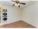 This bedroom has wood floors, a ceiling fan, and laundry in the hallway at 3233 Wood Thrush Dr # 23C, Punta Gorda, FL 33950