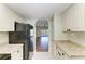 Galley kitchen featuring white cabinets, granite countertops, and modern appliances at 3233 Wood Thrush Dr # 23C, Punta Gorda, FL 33950