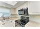 Bright kitchen featuring white cabinets, modern appliances, and a spacious countertop at 3233 Wood Thrush Dr # 23C, Punta Gorda, FL 33950