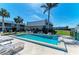 This in-ground pool has lounge chairs and is surrounded by tropical plants at 3233 Wood Thrush Dr # 23C, Punta Gorda, FL 33950