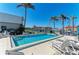 Outdoor swimming pool with lounge chairs, surrounded by palm trees and waterfront views at 3233 Wood Thrush Dr # 23C, Punta Gorda, FL 33950