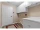 Well-lit laundry room featuring wood-look flooring, modern white cabinetry, and neutral-toned walls at 3959 San Rocco Dr # 612, Punta Gorda, FL 33950