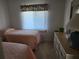 Bedroom with two beds, natural light, and a wooden dresser at 4000 Oakview Dr # L2, Punta Gorda, FL 33980
