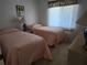Bedroom with two twin beds, natural light, and neutral decor at 4000 Oakview Dr # L2, Punta Gorda, FL 33980
