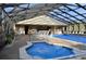 Relaxing indoor pool and spa area with lounge chairs, tables, and chairs at 4000 Oakview Dr # L2, Punta Gorda, FL 33980