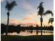 Picturesque sunset view of the pond framed by palm trees at 4000 Oakview Dr # L2, Punta Gorda, FL 33980