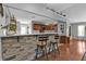 Open kitchen bar with stone accents and seating overlooks the adjacent cooking area at 4334 Sandune Ave, North Port, FL 34287