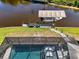 Aerial view of a waterfront property with a private pool and a covered boat dock at 522 Lomond Dr, Port Charlotte, FL 33953