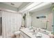 Bright bathroom featuring a single sink vanity, large mirror, and decorative shower curtain at 5244 Early Ter, Port Charlotte, FL 33981