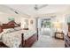 Comfortable Primary bedroom with a wooden bed frame, ceiling fan, and sliding glass doors to patio at 5244 Early Ter, Port Charlotte, FL 33981