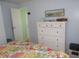 Cozy bedroom featuring a dresser, closet, and charming floral bedding with colorful pillows and a nautical painting at 5632 Holiday Park Blvd, North Port, FL 34287