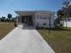 Charming single-story home with a covered porch and well-manicured lawn at 5632 Holiday Park Blvd, North Port, FL 34287